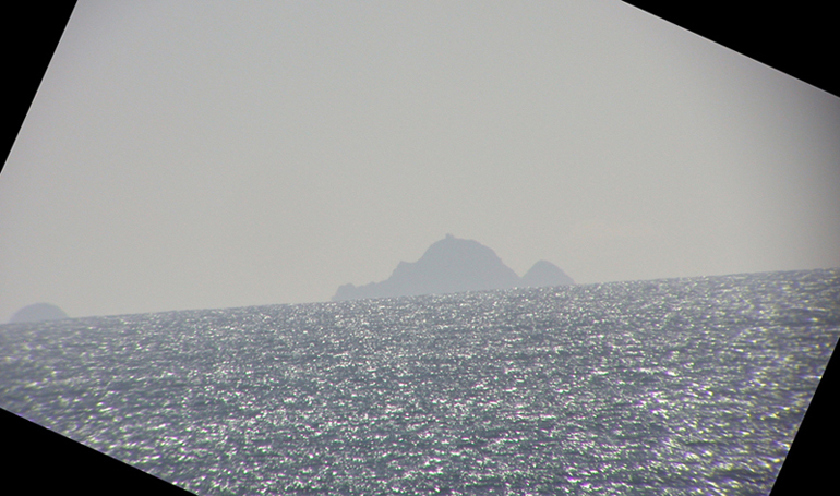 Through a telescope, the Farallon Islands of the Pacific Coast are visible