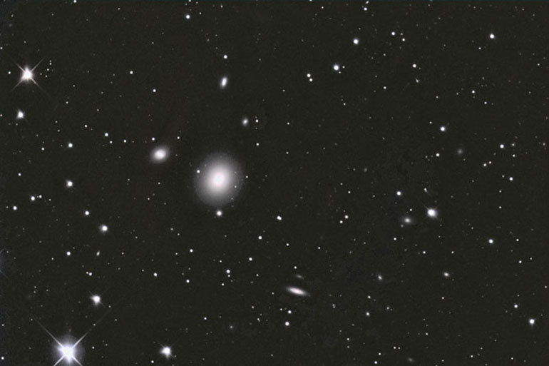 This is elliptical galaxy NGC 4261, member of the Virgo cluster. Numerous smaller galaxies are also seen in this image. This particular image suffered from severe gradient which was painfully removed over many hours - digital artifacts remain as a result.