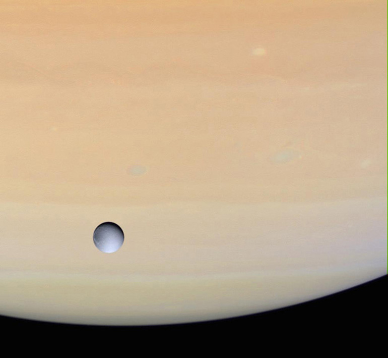 A Cassini image of Dione against Saturn.